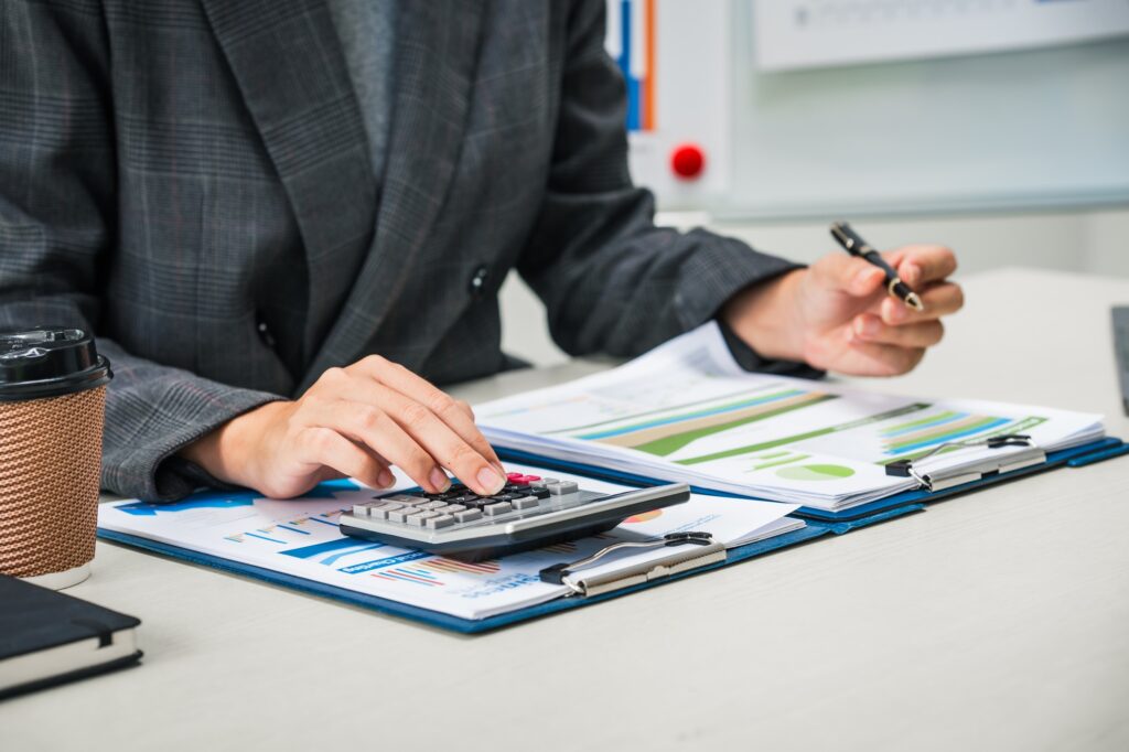 businesswoman works diligently at her desk, reviewing financial documents and analyzing investment businesswoman works diligently at her desk, reviewing financial documents and analyzing investment